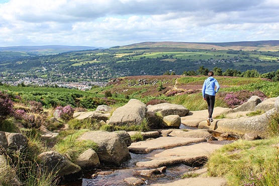 ​​​​​​​Flat slabs at Backstone Beck high above Ilkley with Beamsley Beacon beyond