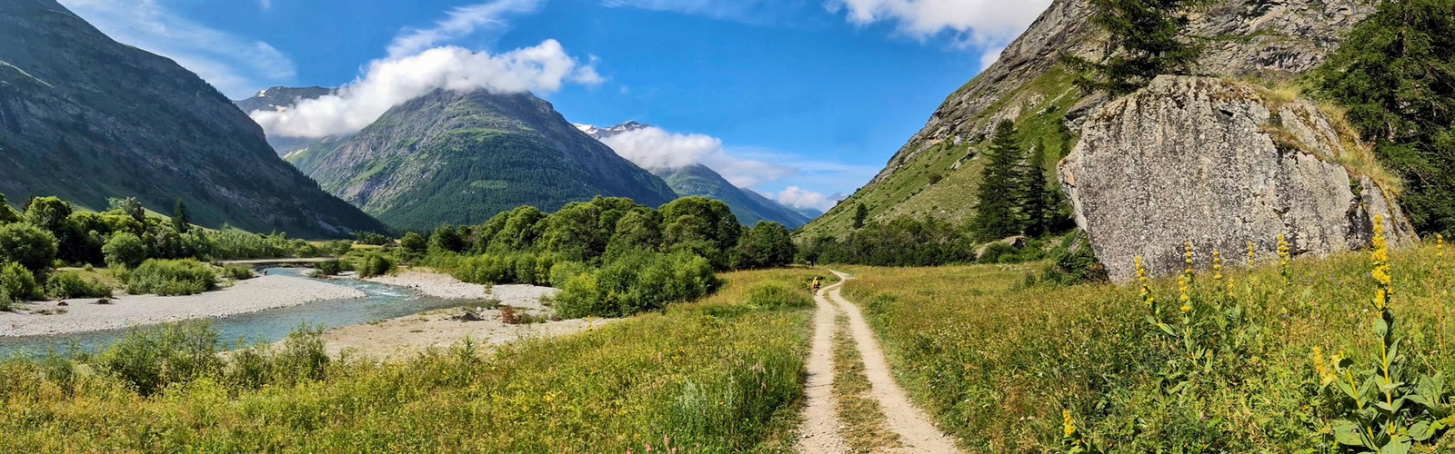 A clear track runs close to a river between Bonneval-sur-Arc and Le Villaron, GR5 - French Alps