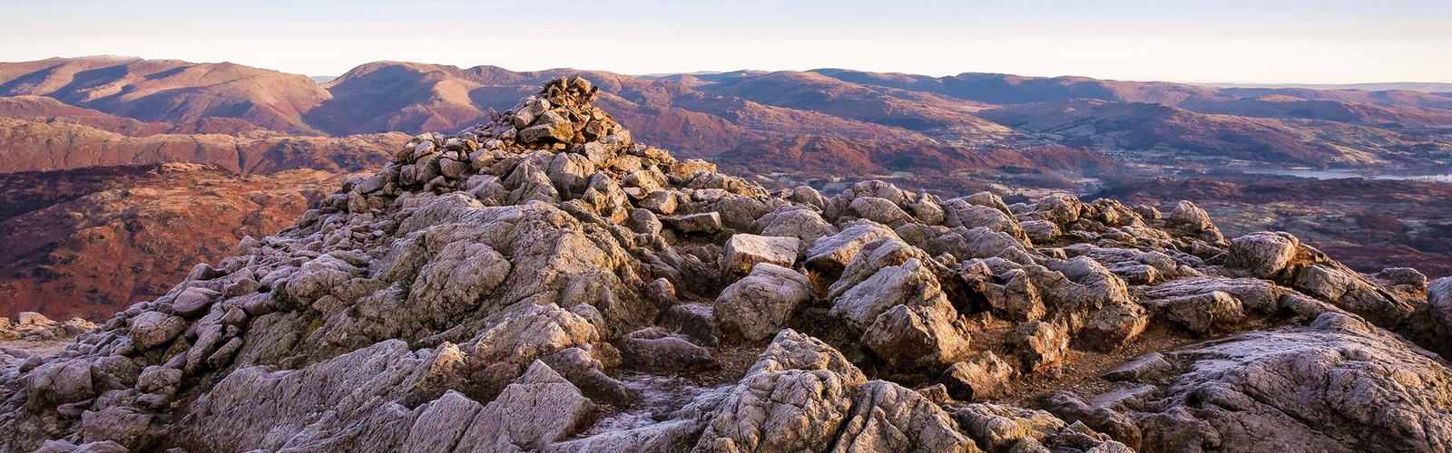 A frosty winter’s morning on the summit of Wetherlam, the Fairfield range of fells sit on the horizon