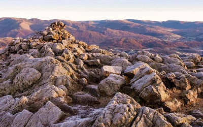 A frosty winter’s morning on the summit of Wetherlam, the Fairfield range of fells sit on the horizon